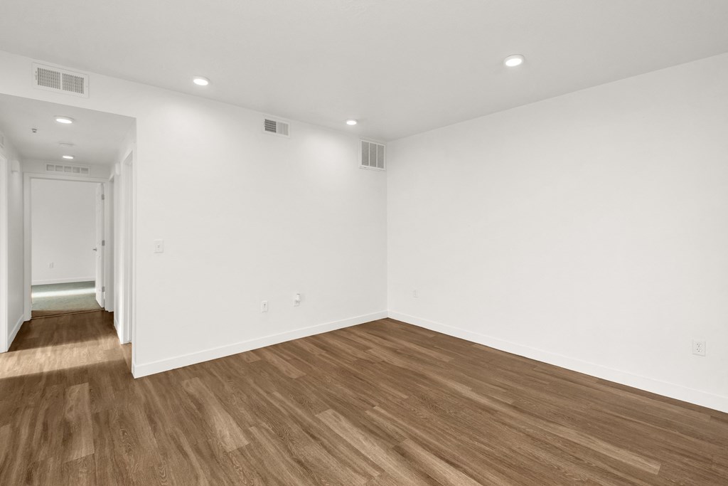 a living room with white walls and wood floors