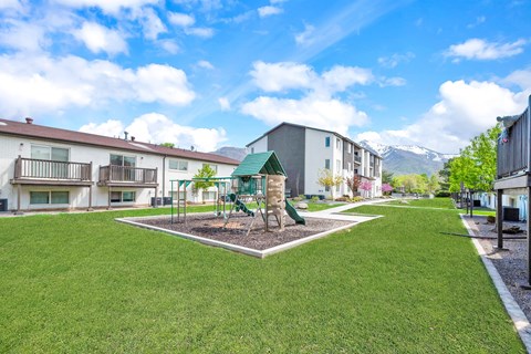 a park with a playground in the middle of some apartments