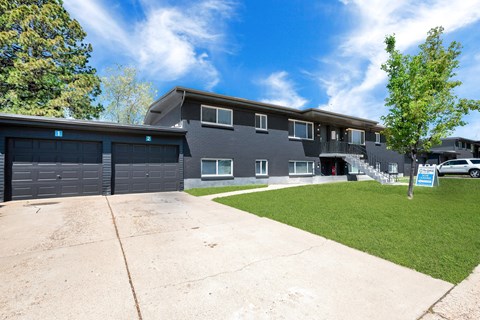 the front of a house with a driveway and garage doors