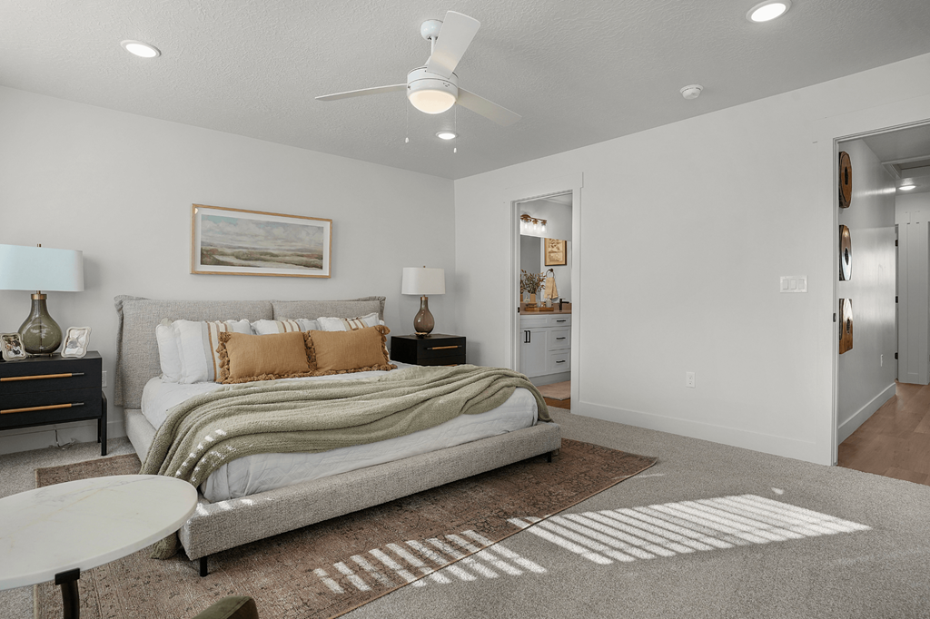 A bedroom with a bed, nightstands, and a ceiling fan.
