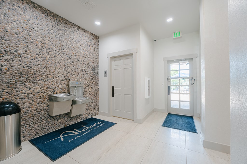 a bathroom with a urinal and a sink and a door at Aldara Apartments in Saratoga Springs, Utah