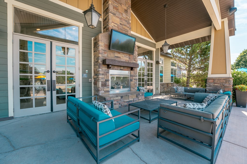 the preserve at ballantyne commons covered patio with furniture and a fireplace at Aldara Apartments in Saratoga Springs, Utah