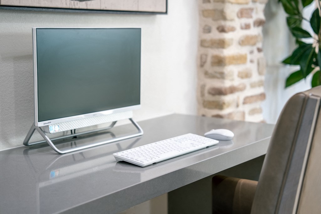 a desk with a computer monitor and a keyboard and mouse at Aldara Apartments in Saratoga Springs, Utah