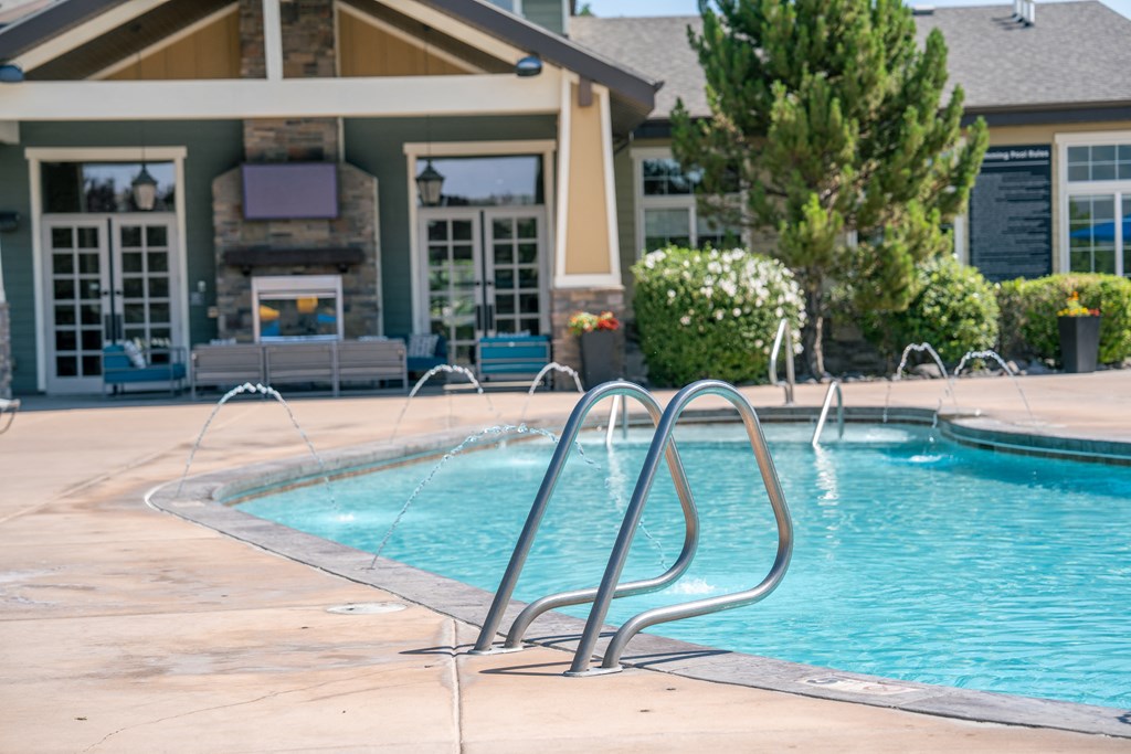 a swimming pool with water fountains in front of a house at Aldara Apartments in Saratoga Springs, Utah
