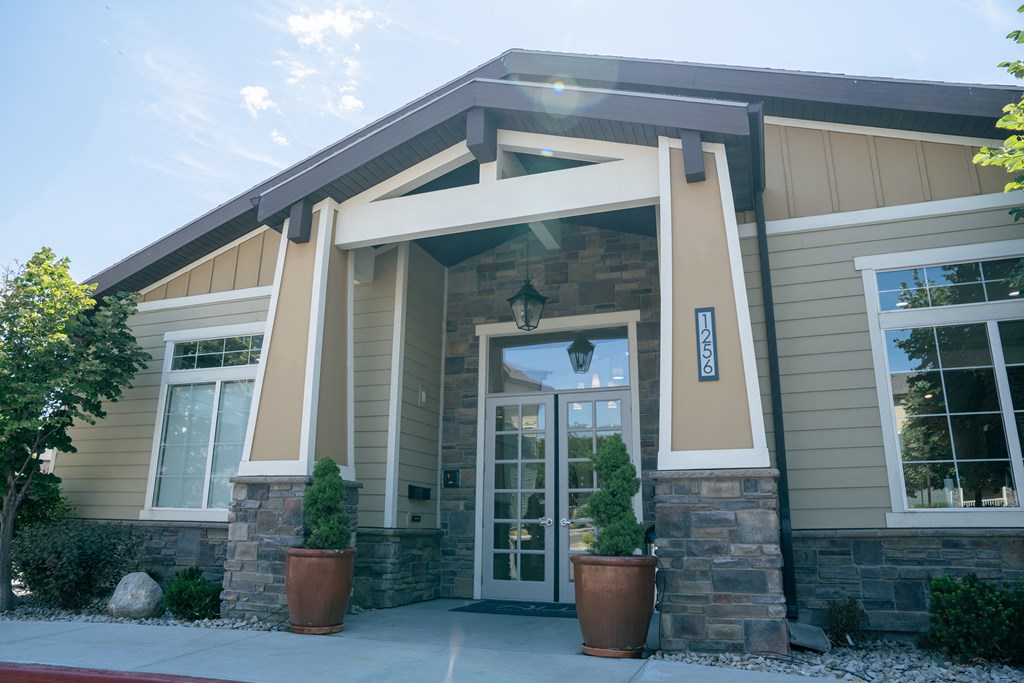 the front of a building with two potted plants in front of it at Aldara Apartments in Saratoga Springs, Utah