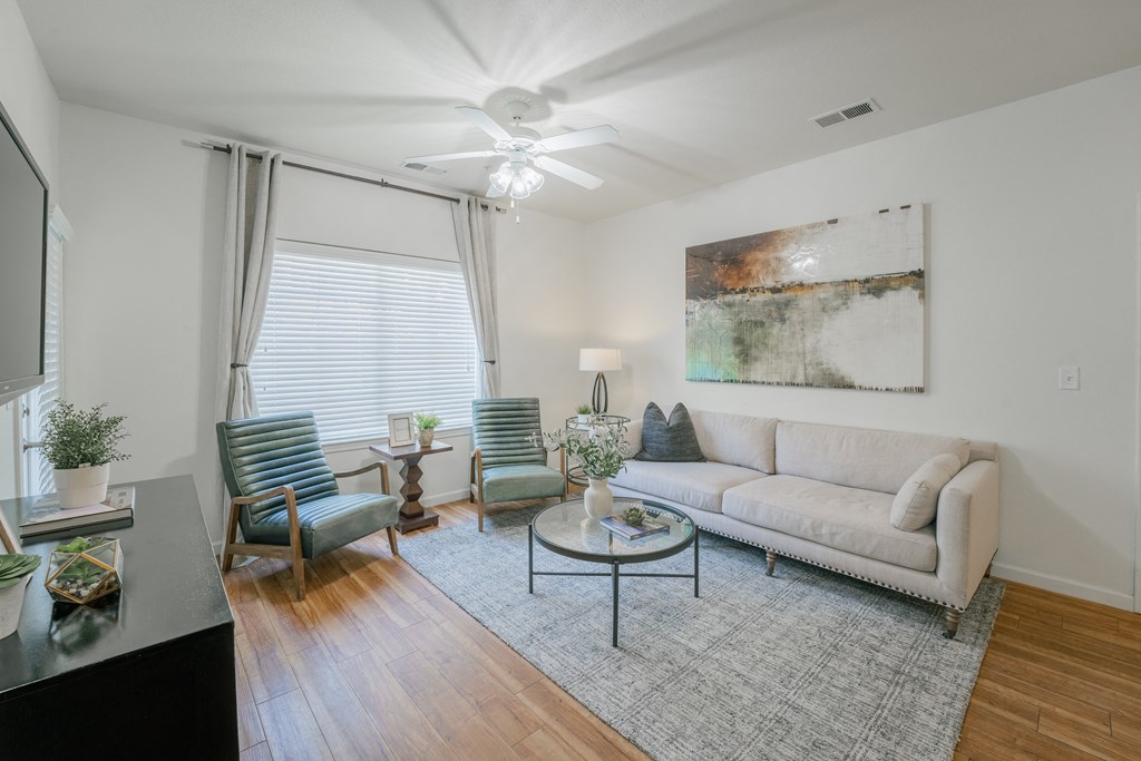 a living room with a couch and chairs and a ceiling fan at Aldara Apartments in Saratoga Springs, Utah
