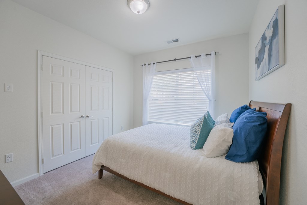 an empty bedroom with a bed and a window at Aldara Apartments in Saratoga Springs, Utah