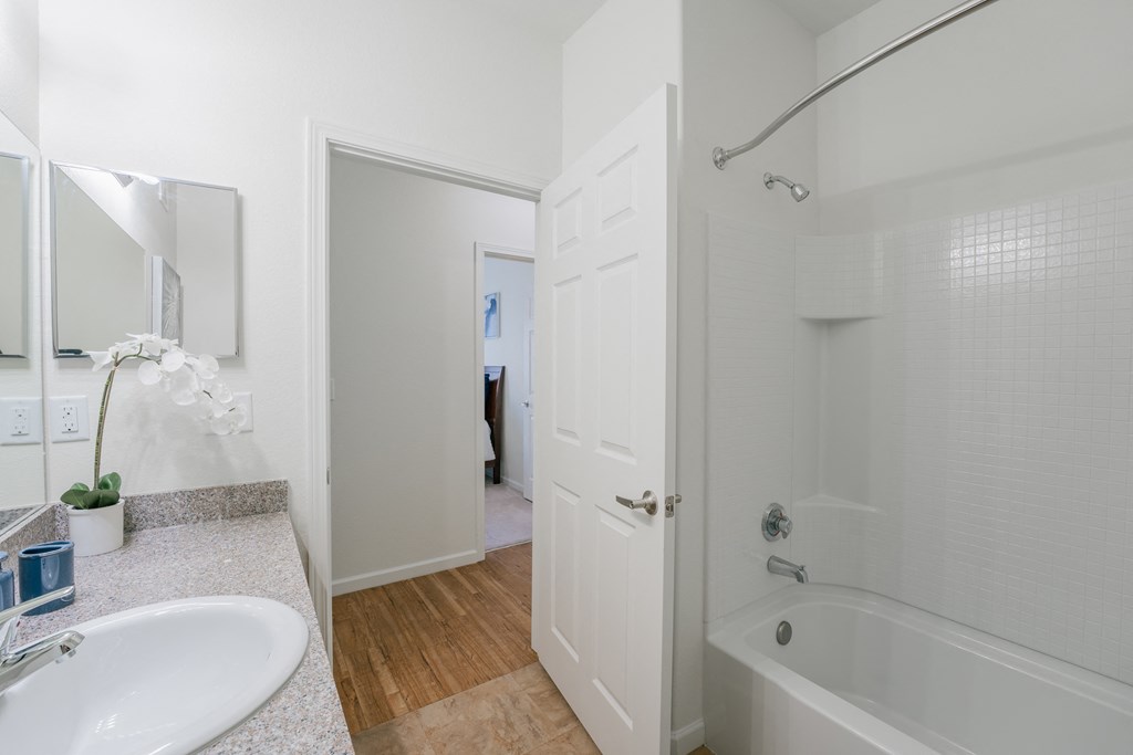 a bathroom with a tub and a sink and a mirror at Aldara Apartments in Saratoga Springs, Utah