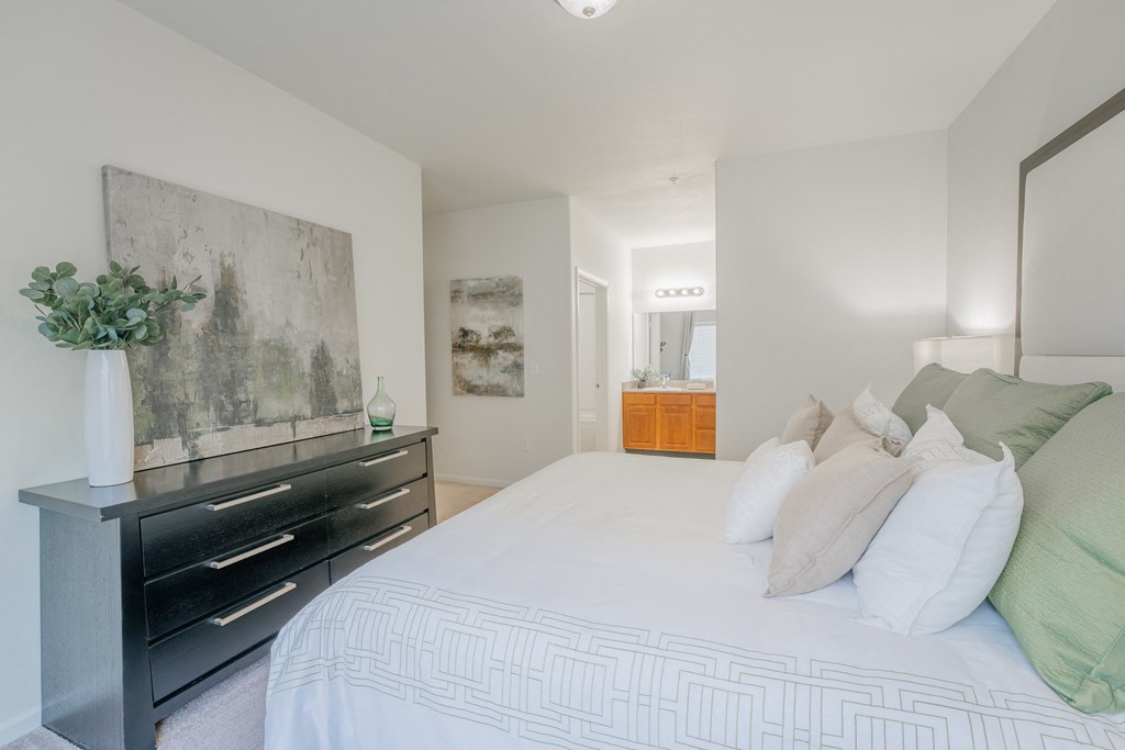 a bedroom with a large white bed and a black dresser at Aldara Apartments in Saratoga Springs, Utah