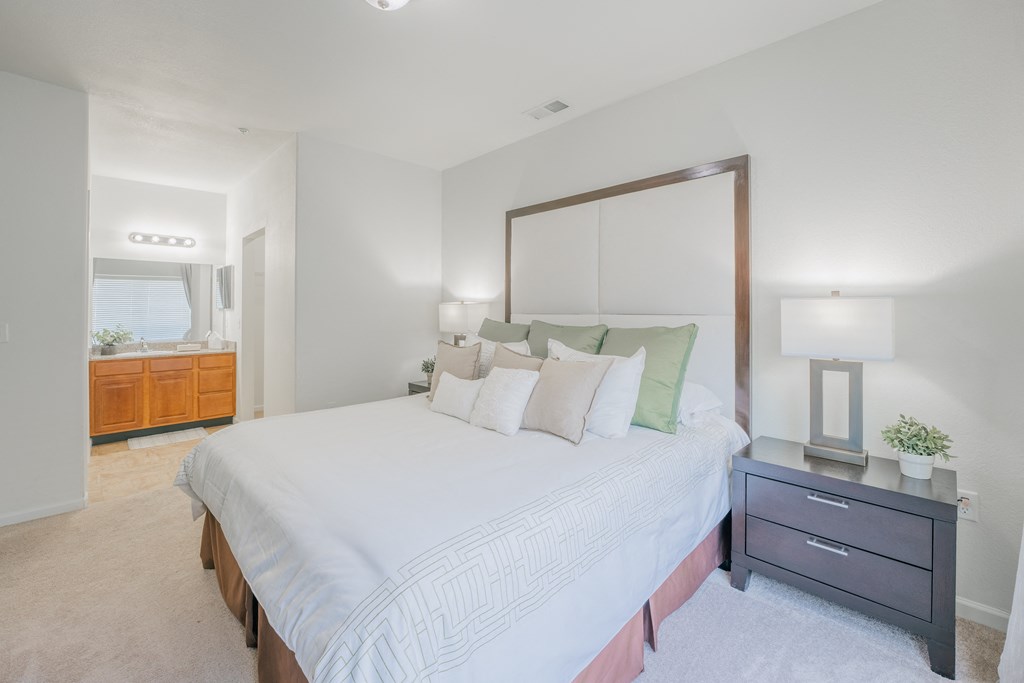 a bedroom with a large white bed and a mirror at Aldara Apartments in Saratoga Springs, Utah