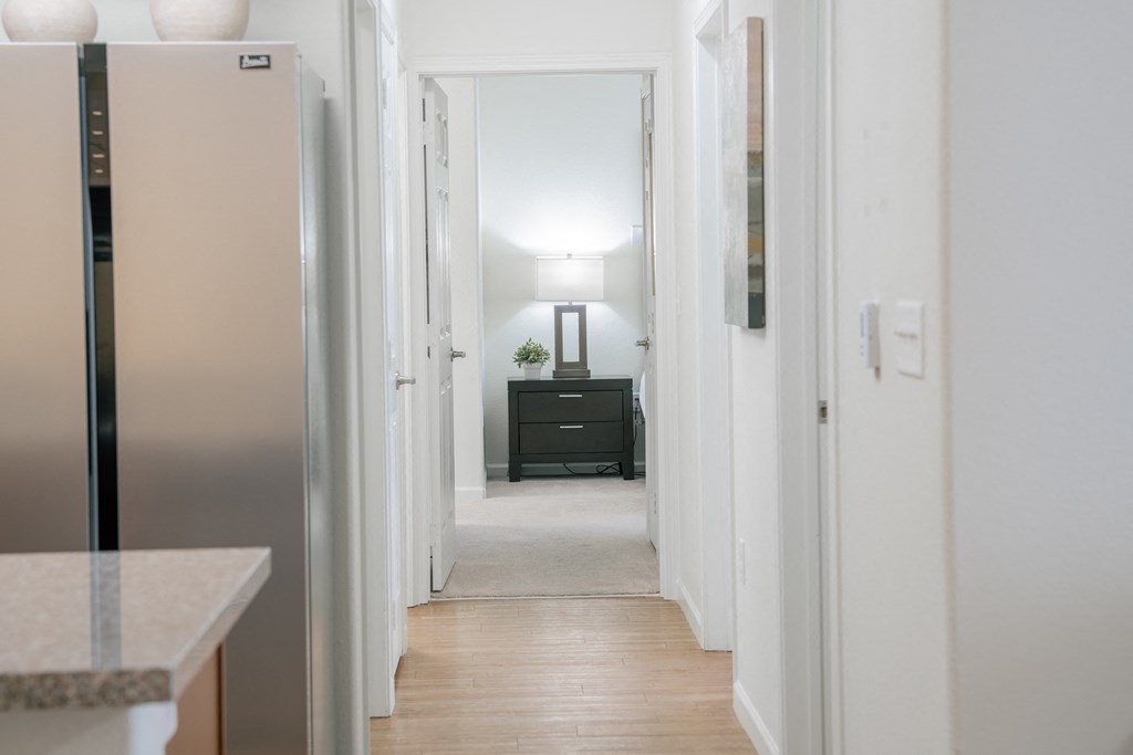 a view of a hallway in a home with a refrigerator and a black dresser at Aldara Apartments in Saratoga Springs, Utah