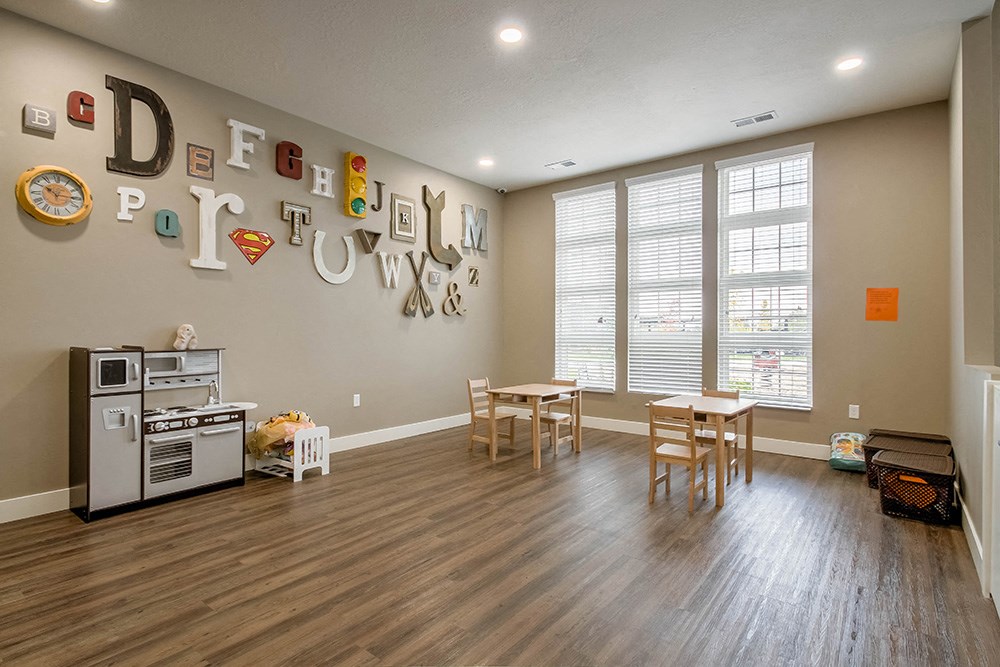 a playroom with a table and chairs and a stove