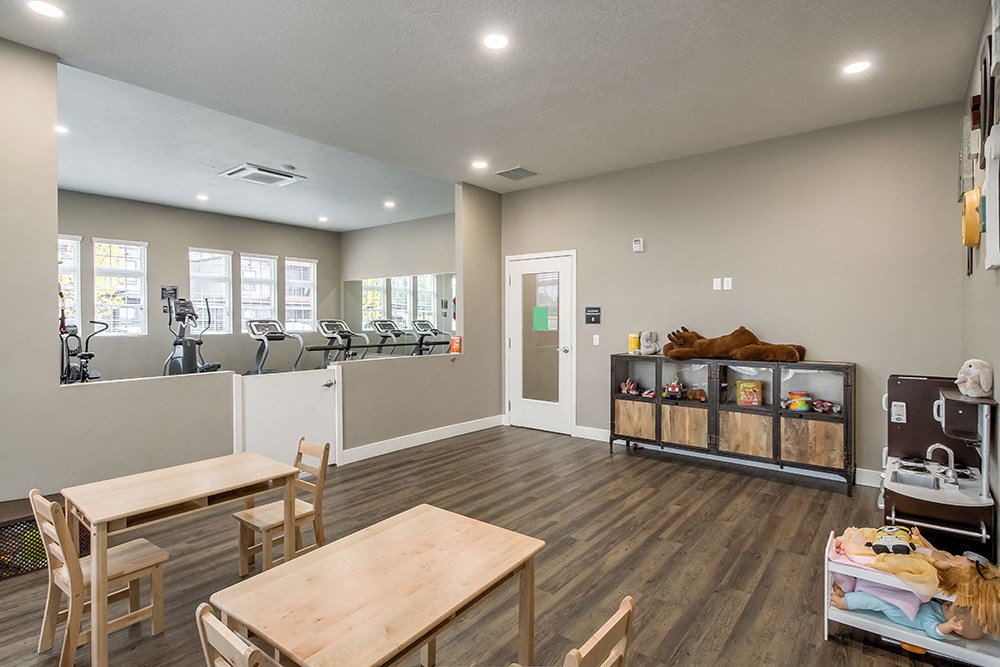 a fitness room with a table and chairs and a treadmill