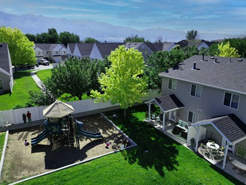 a aerial view of a backyard with a playground and houses
