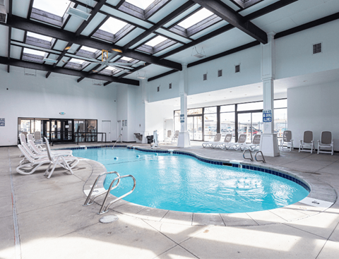 A large indoor swimming pool with sun loungers.