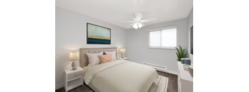 A bedroom with a large bed, a ceiling fan, and a painting on the wall.