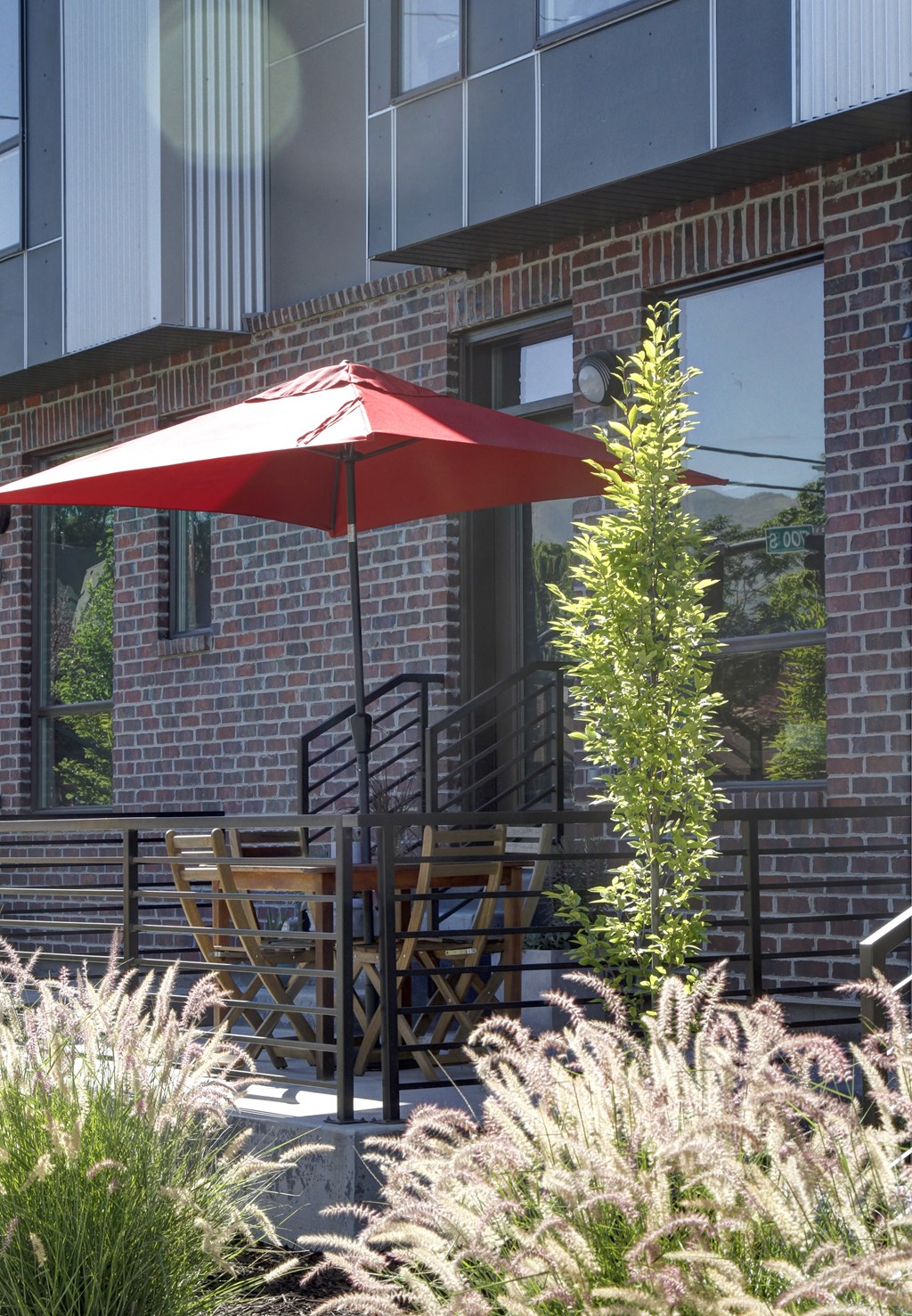 a patio with a red umbrella and a table and chairs at BlueKoi Townhomes for rent in Salt Lake City, UT