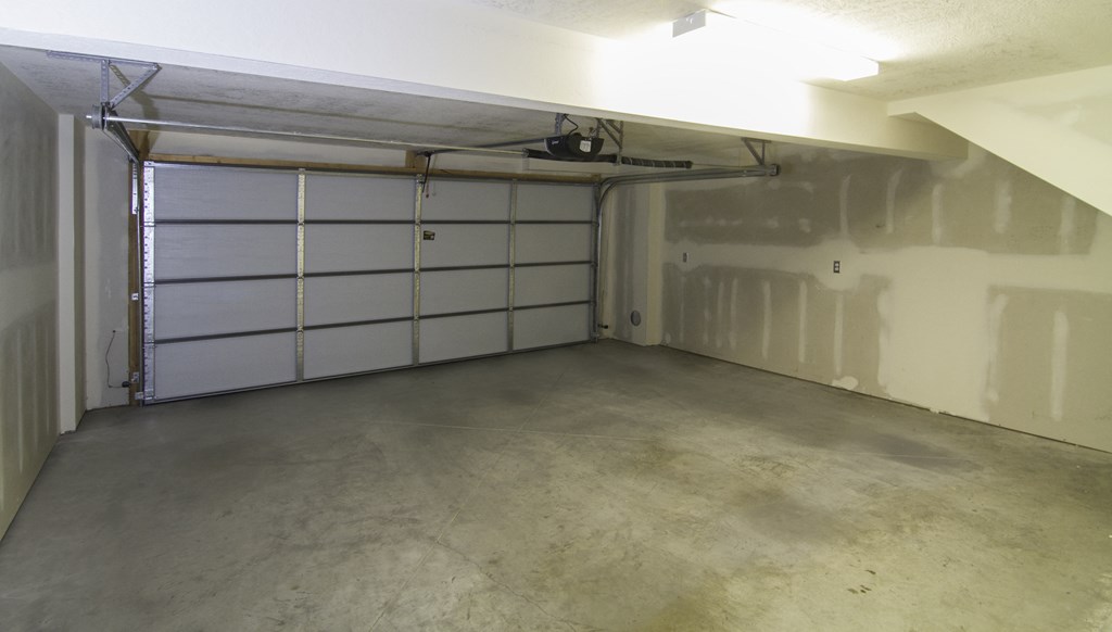 the inside of a garage with a white garage door at BlueKoi Townhomes for rent in Salt Lake City, UT