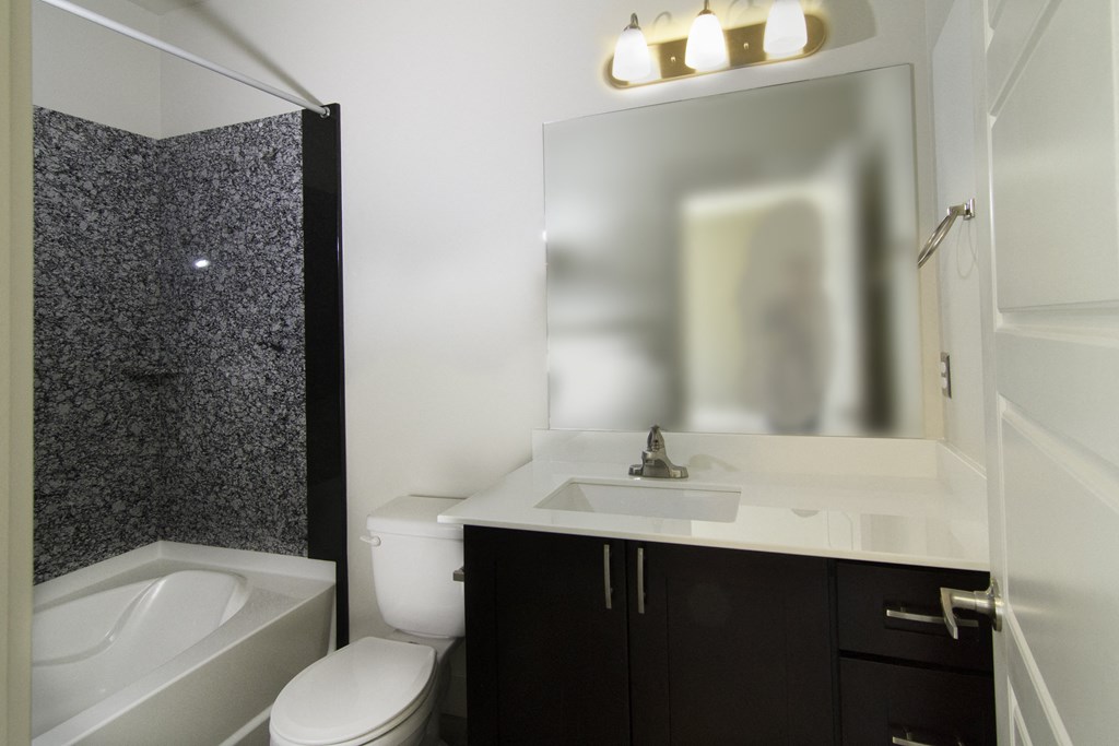 a bathroom with a sink, toilet and mirror and a tub at BlueKoi Townhomes for rent in Salt Lake City, UT