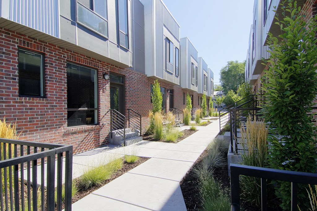 a sidewalk in front of a brick apartment building at BlueKoi Townhomes for rent in Salt Lake City, UT