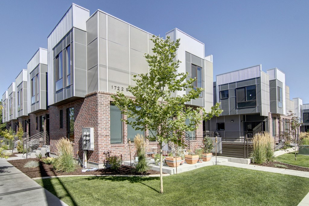 the exterior of an apartment building with grass and a tree at BlueKoi Townhomes for rent in Salt Lake City, UT