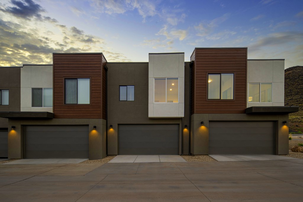 A modern house with a brown and beige exterior and a garage door.