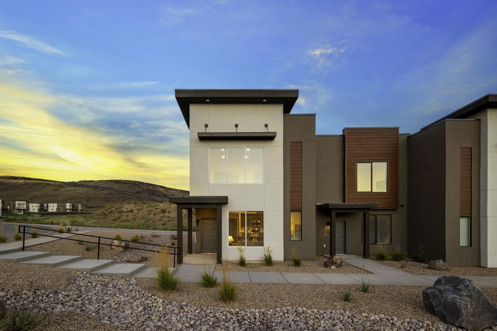 A modern house with a flat roof and a stone pathway leading to the entrance.