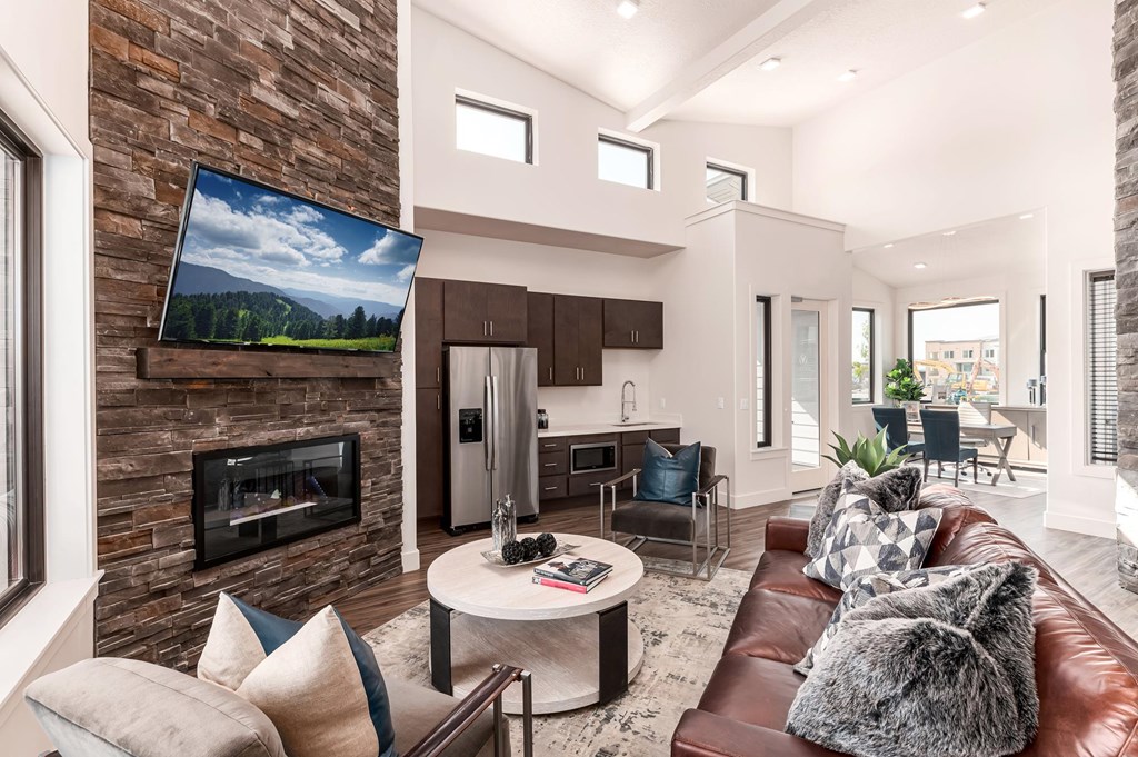 A modern living room with a stone wall and a flat screen TV.