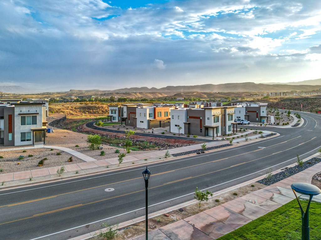 A street view of a residential area with houses on the side and a road in the foreground.