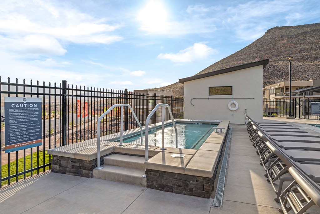 A pool area with a caution sign and a hot tub.