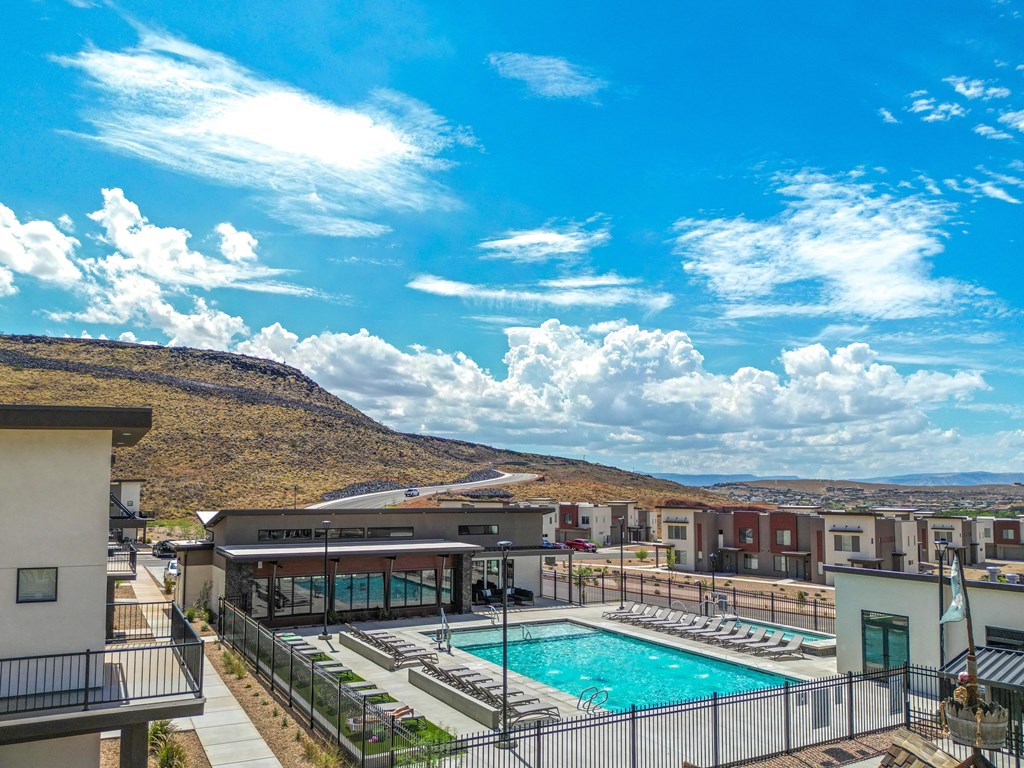 A swimming pool surrounded by a fence and a building in the background.