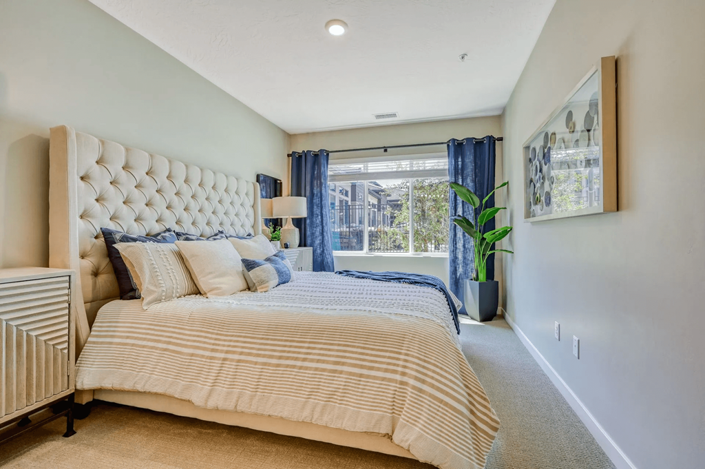 a spacious bedroom with a large bed and a window at Brookfield Apartments for rent in St. George, UT.