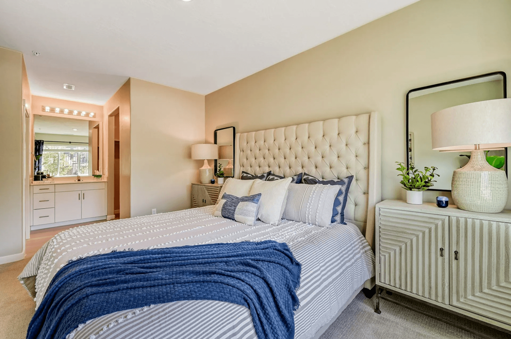 a bedroom with a large bed and a mirror