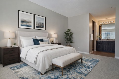 A bedroom with a large bed and two lamps.
