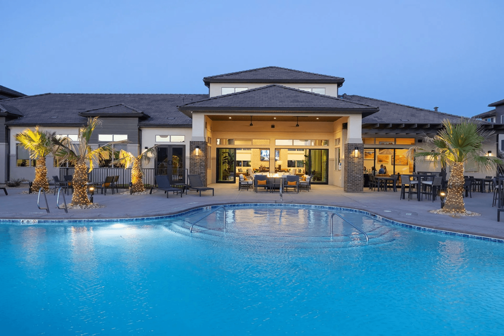 a swimming pool in front of a house with a resort style pool
