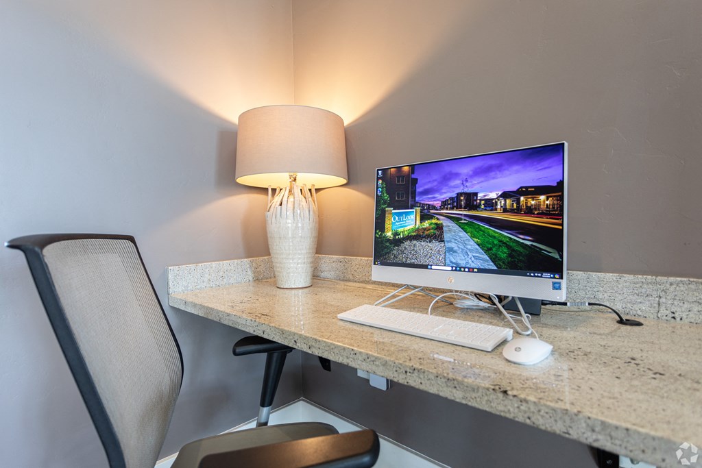 a computer on a desk in a room with a lamp or a work desk area at Outlook Apartments for rent in Springville and Provo, UT.