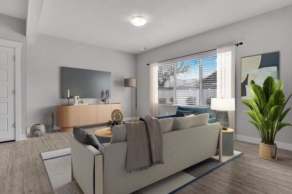 A living room with a couch, a mirror, a lamp, and a potted plant.