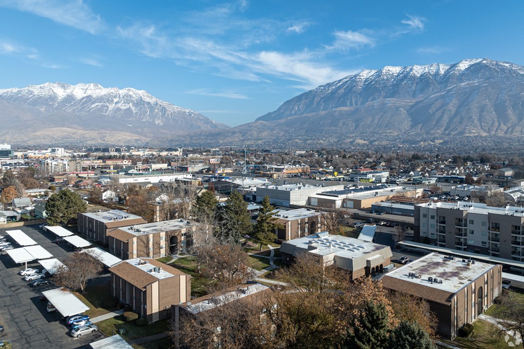 A view of a town with buildings and snow-capped mountains in the background.