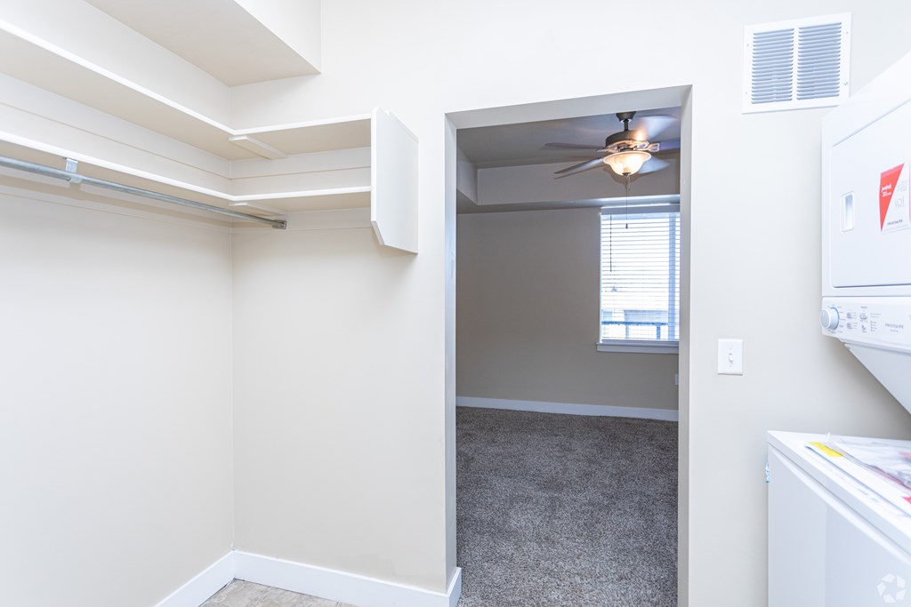 A room with a ceiling fan and a window.