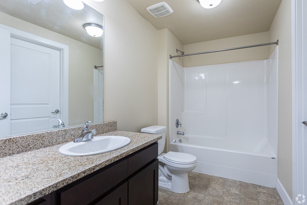 A bathroom with a sink, toilet, and bathtub.
