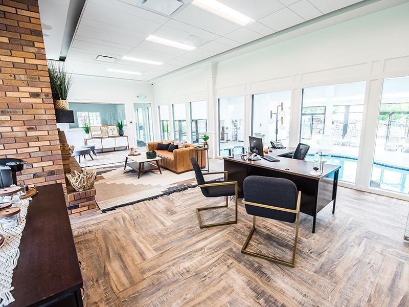 A modern office space with a brick wall and wooden flooring.