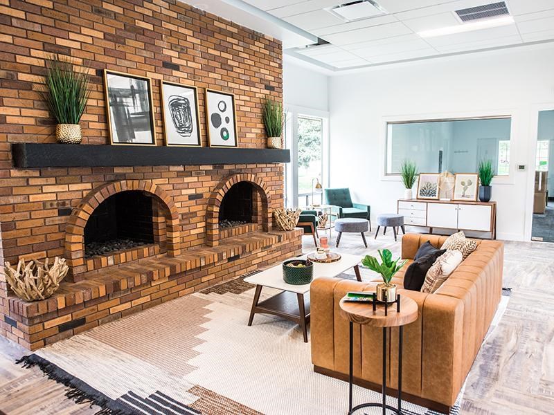A living room with a brick fireplace and a couch.