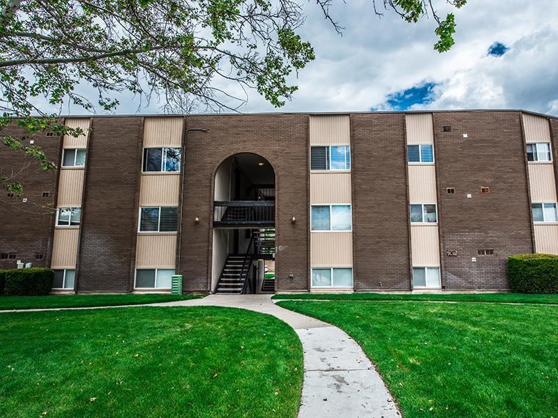 A large brick building with a green lawn in front.