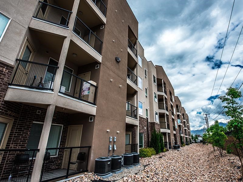 A row of apartment buildings with balconies and black railings.