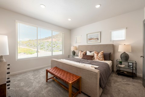 A bedroom with a large bed and a bench in front of it.
