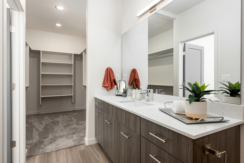 A bathroom with a sink, mirror, and towel rack.