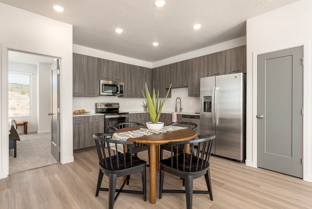 A modern kitchen with a dining table set for four.