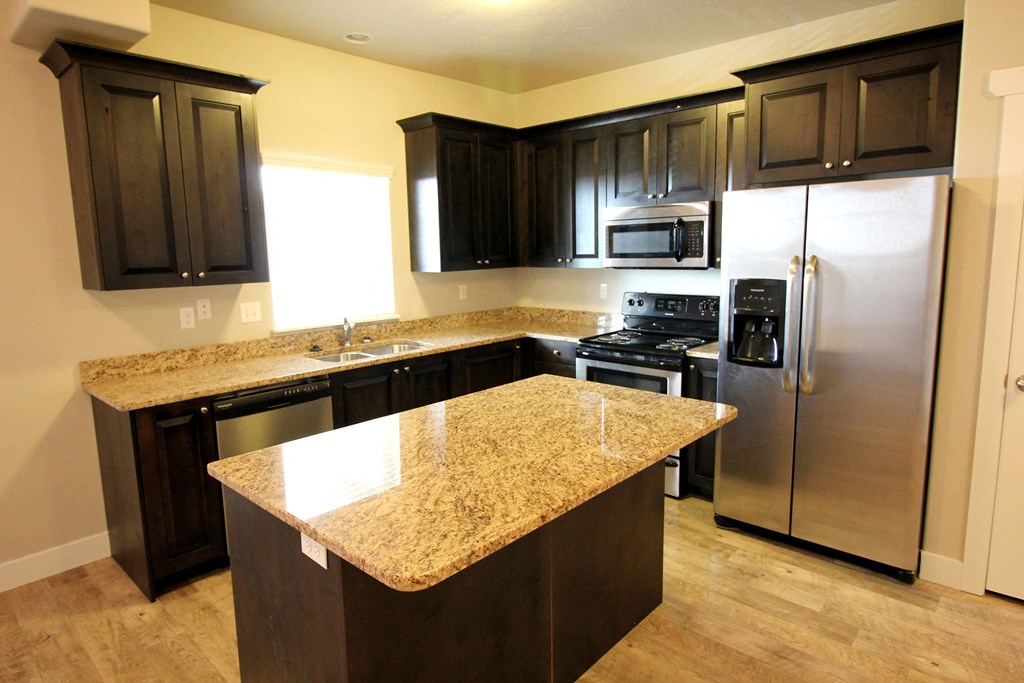 a kitchen with granite countertops and stainless steel appliances