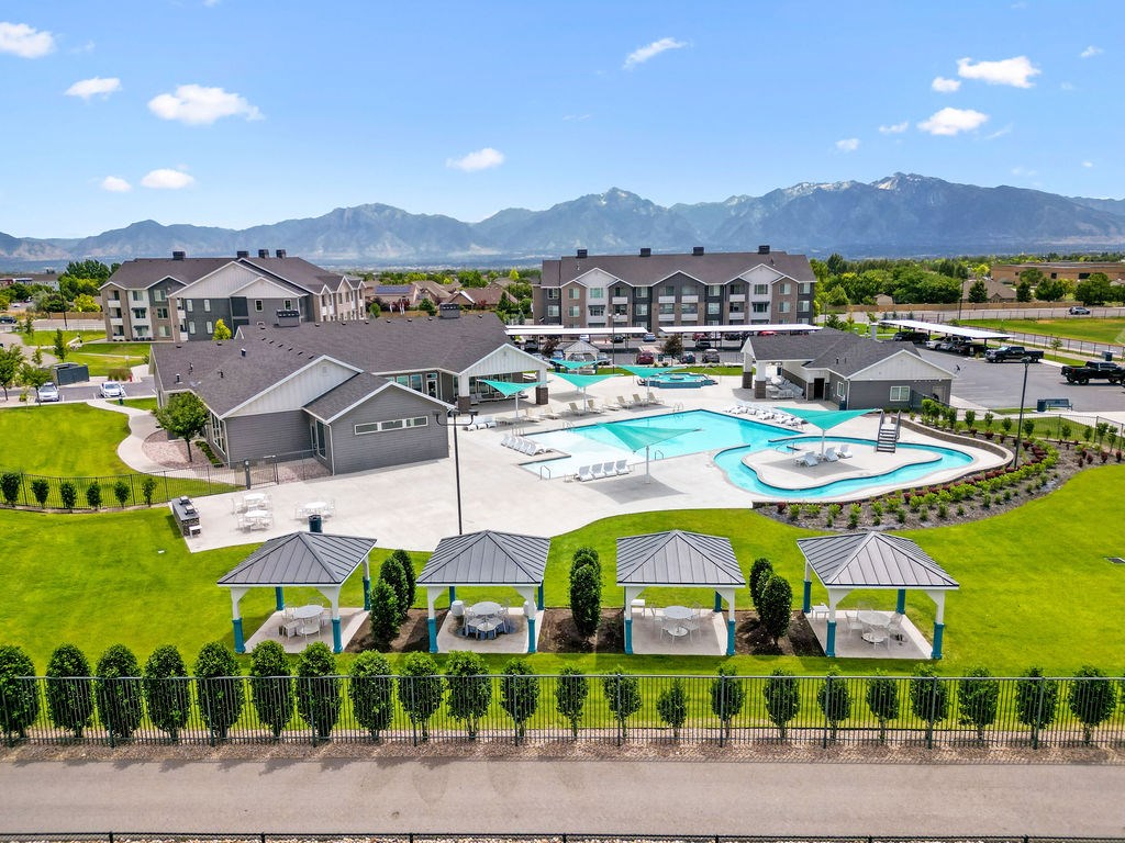 Affinity 56 Apartments for rent in West Jordan, UT  A resort with a pool and a mountain in the background.