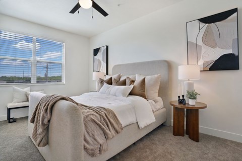 A bedroom with a large bed and a ceiling fan.